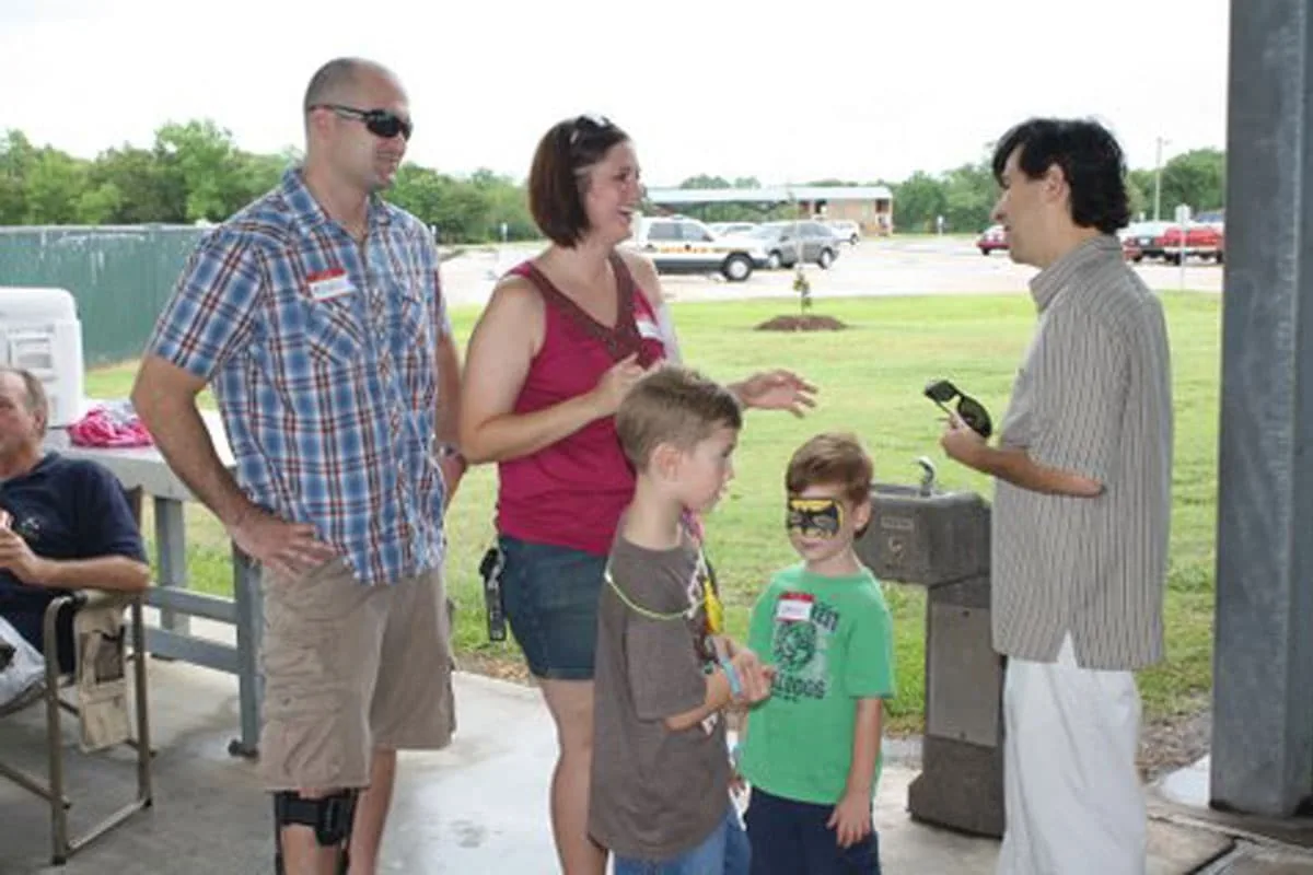 Dr. Arturo Bonilla speaks with a family including two young boys with face paint at an outdoor microtia patient picnic event in San Antonio. Dr. Bonilla hosts community picnic gatherings where microtia families can meet, share experiences, and connect with other families on the same journey.