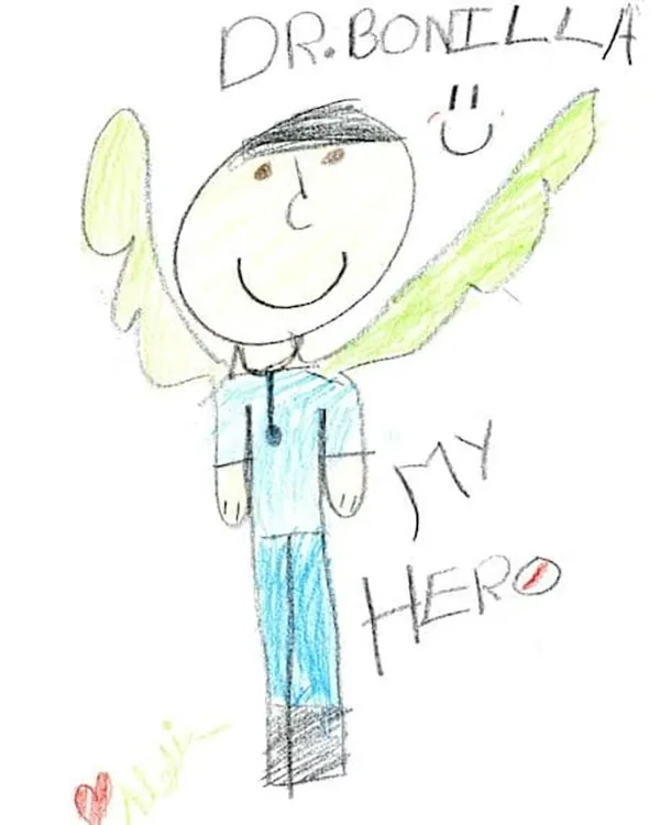 Child's crayon drawing of Dr. Arturo Bonilla with angel wings and the words Dr. Bonilla My Hero — a gift from a grateful microtia patient.