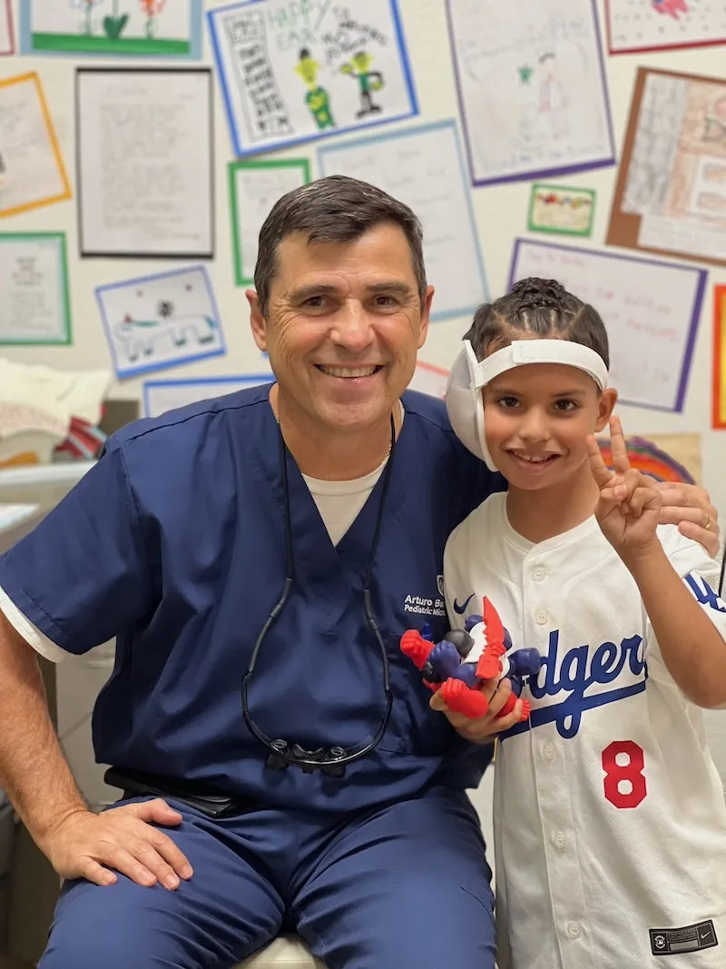 Dr. Arturo Bonilla with a young microtia patient during consultation at his San Antonio surgical practice