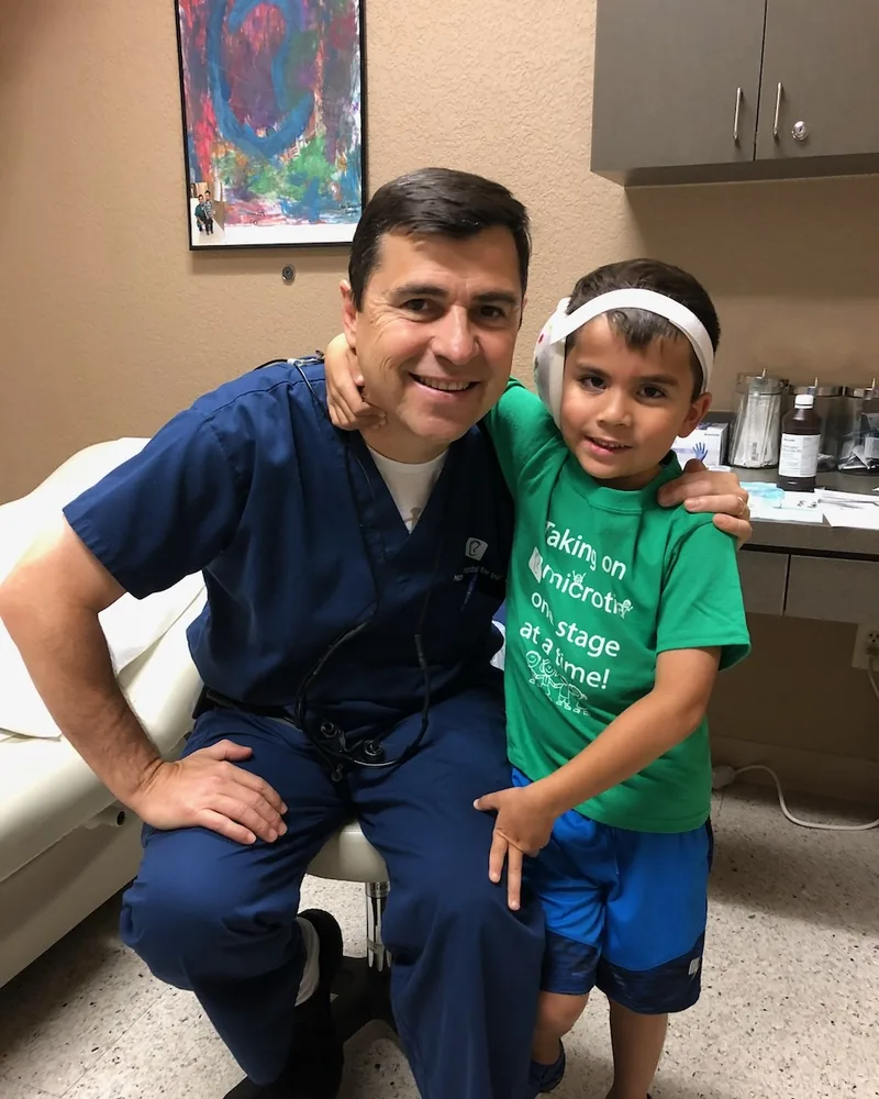 Dr. Arturo Bonilla with happy microtia patient after successful ear reconstruction surgery