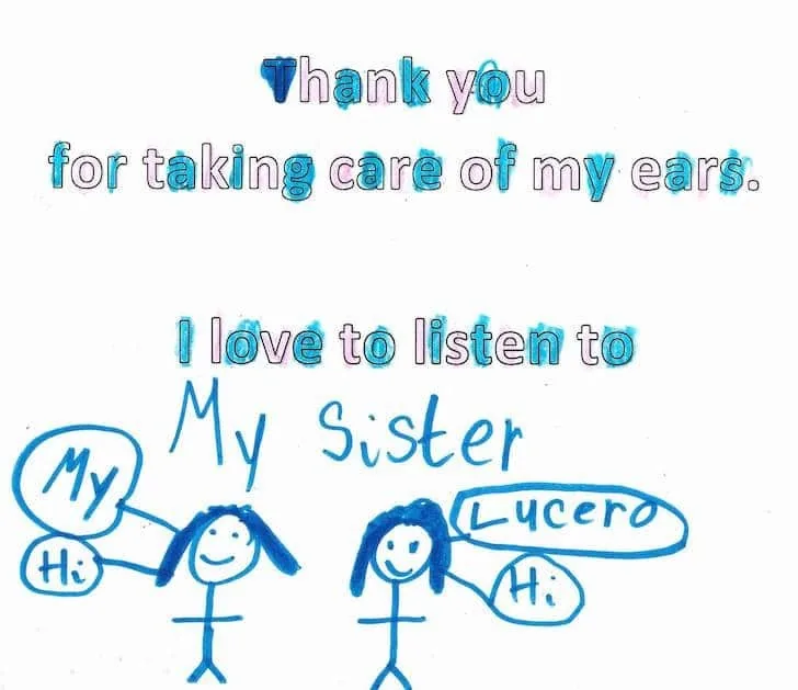 Tarjeta hecha con marcador azul que muestra dos figuras de palitos con globos de diálogo, escrita por un niño que dice que le encanta escuchar a su hermana Lucero después de que el Dr. Arturo Bonilla cuidara sus orejas: un dulce y conmovedor regalo de un paciente joven que se sometió a cirugía de microtia