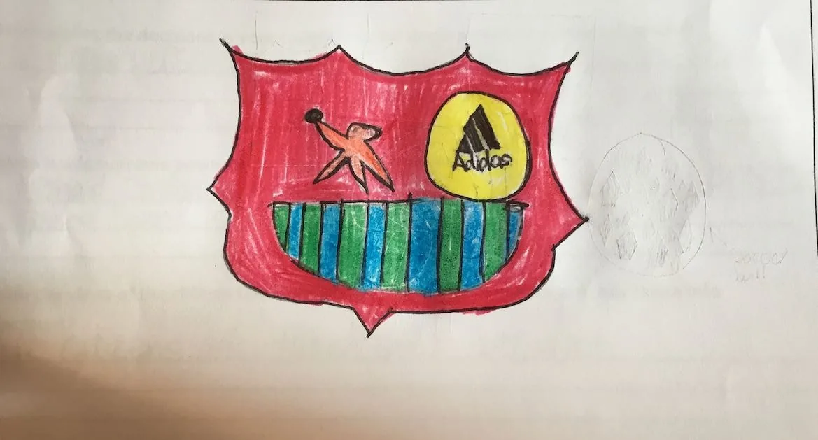 Dibujo infantil con crayones de un escudo rojo de fútbol con un logotipo de Adidas y un emblema de ave con franjas verdes y azules: un regalo de agradecimiento de temática deportiva al Dr. Arturo Bonilla de un paciente agradecido que se sometió a cirugía de microtia